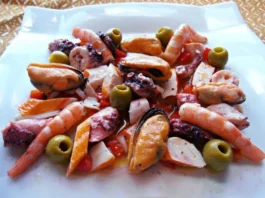 Salpicón de marisco con langostinos, pulpo, mejillones y palitos de mar, servido en fuente blanca