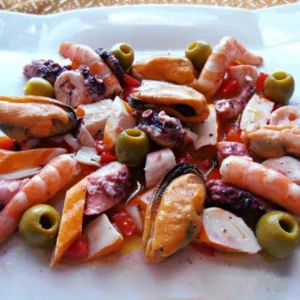 Salpicón de marisco con langostinos, pulpo, mejillones y palitos de mar, servido en fuente blanca