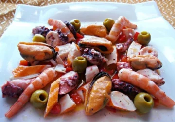 Salpicón de marisco con langostinos, pulpo, mejillones y palitos de mar, servido en fuente blanca
