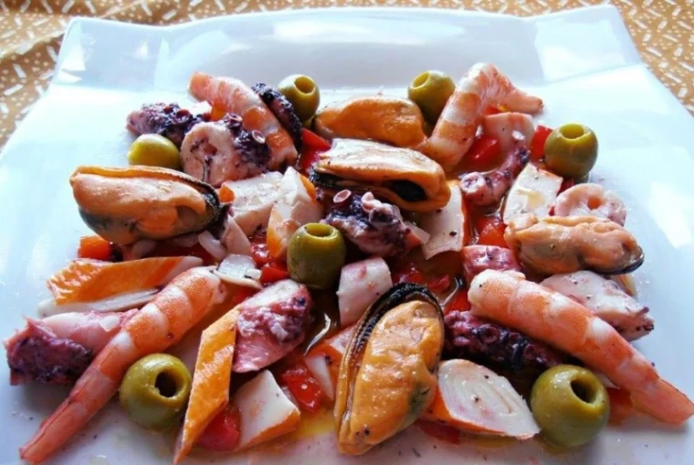 Salpicón de marisco con langostinos, pulpo, mejillones y palitos de mar, servido en fuente blanca