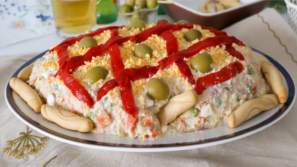 Ensaladilla rusa decorada, servida en una fuente