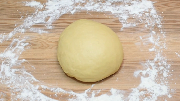 Bola de masa casera del hornazo de Salamanca recién amasada sobre superficie enharinada