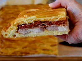Porción de hornazo de Salamanca casero mostrando las capas de lomo, jamón y chorizo entre la masa dorada con rejilla