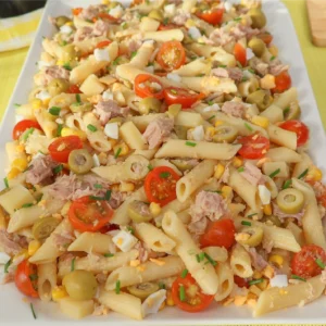 Ensalada de pasta con atún servida en fuente rectangular blanca