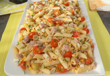 Ensalada de pasta con atún servida en fuente rectangular blanca