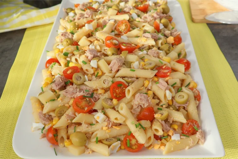 Ensalada de pasta con atún servida en fuente rectangular blanca