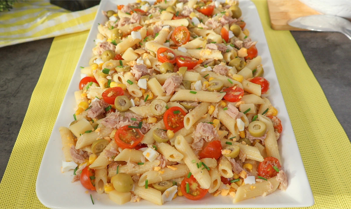 Ensalada de pasta con atún servida en fuente rectangular blanca