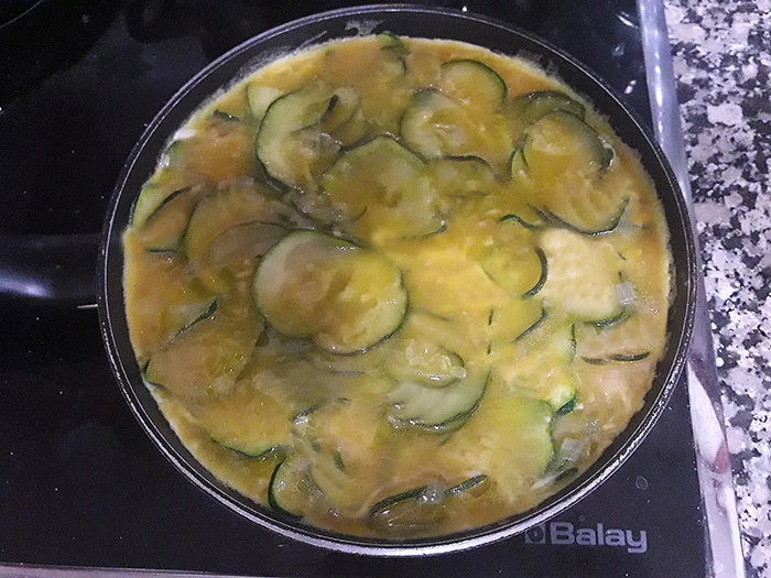 Mezcla de huevo y calabacín cocinándose en sartén