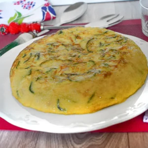 ortilla de calabacín entera servida en plato blanco