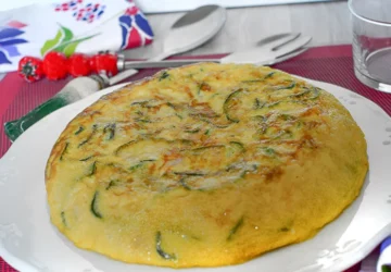 ortilla de calabacín entera servida en plato blanco