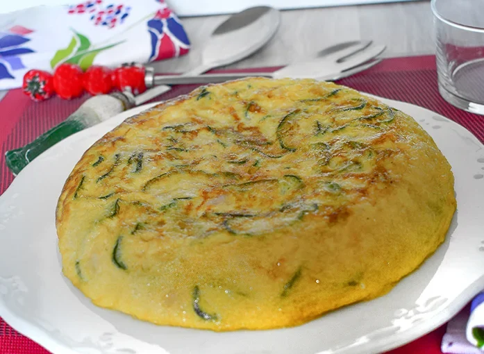 ortilla de calabacín entera servida en plato blanco