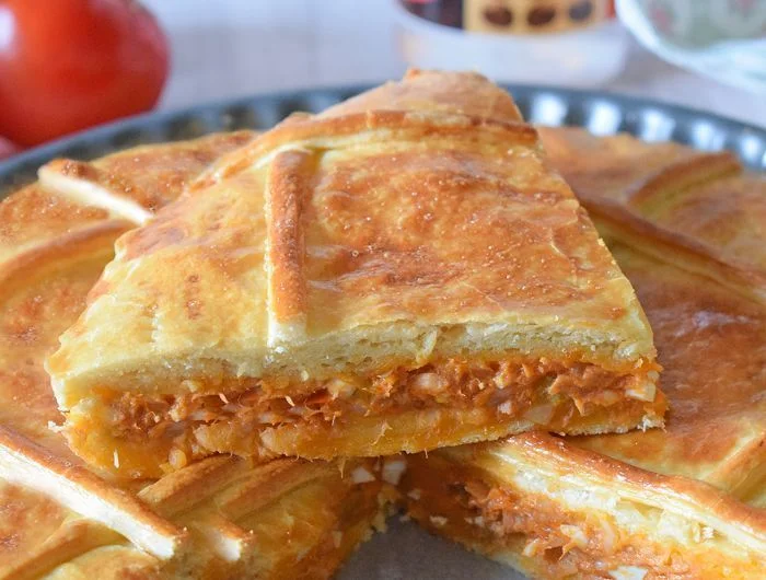 Corte de empanada de atún con relleno jugoso de tomate y huevo