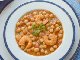 Garbanzos con langostinos servidos en plato hondo, guiso tradicional