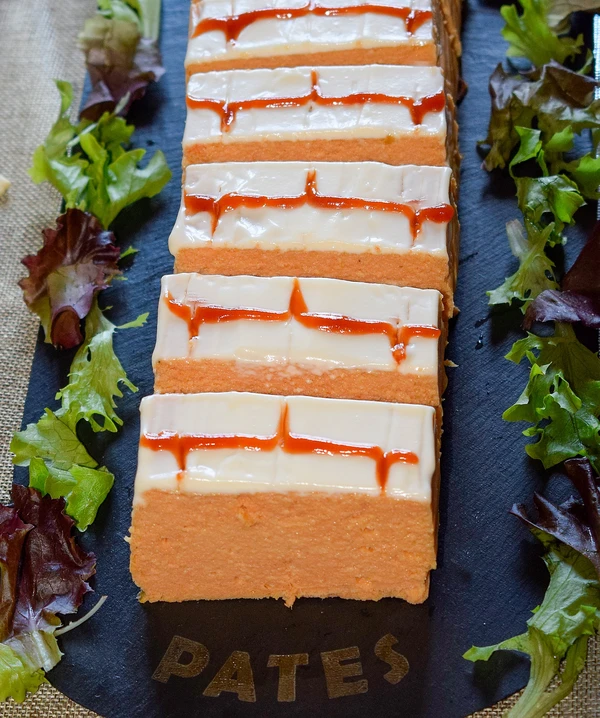 Pastel de pescado casero de merluza y langostinos decorado con mayonesa y ketchup