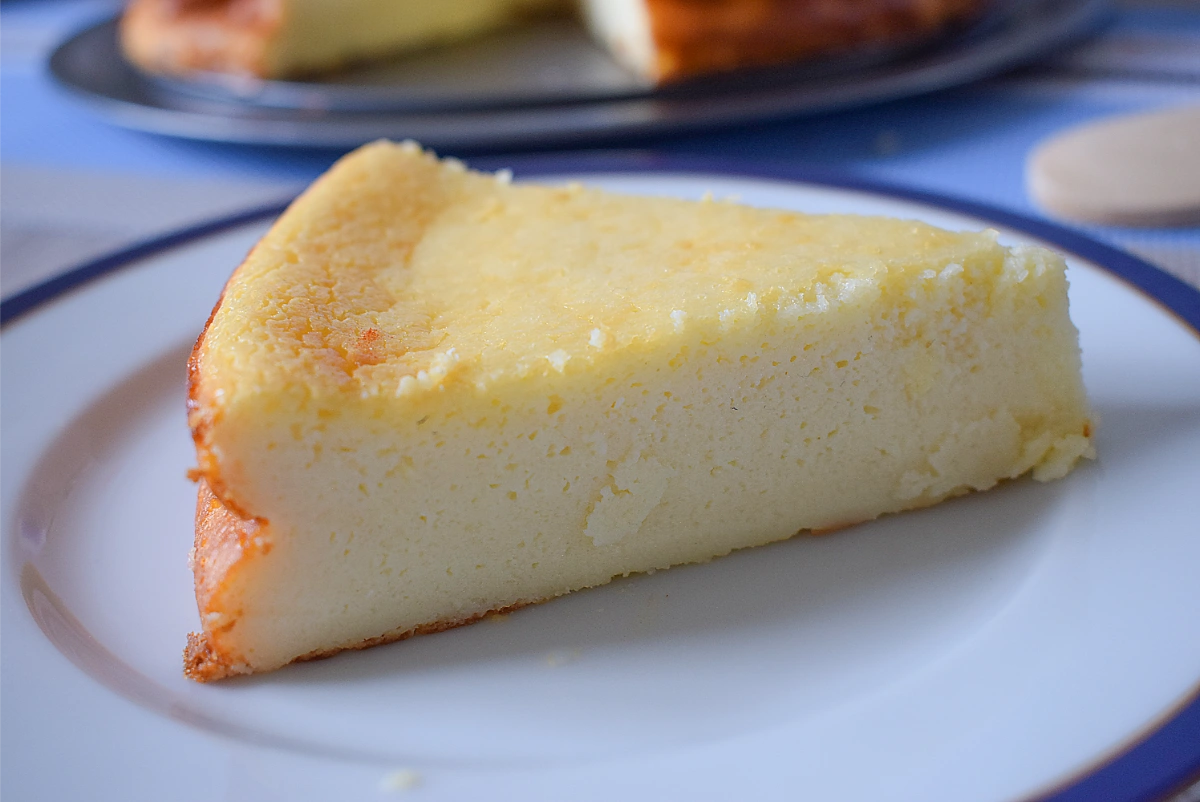 Porción de tarta de queso al horno servida en plato con la textura cremosa visible en el corte