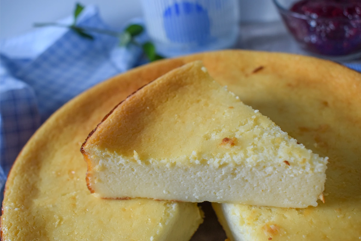Porción de tarta de queso al horno levantada mostrando la textura esponjosa y cremosa del interior