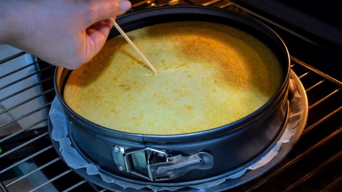 Comprobando si la tarta de queso al horno está cuajada pinchando con un palillo en el centro