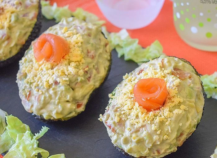 Aguacates rellenos de salmón ahumado y salsa rosa sobre pizarra