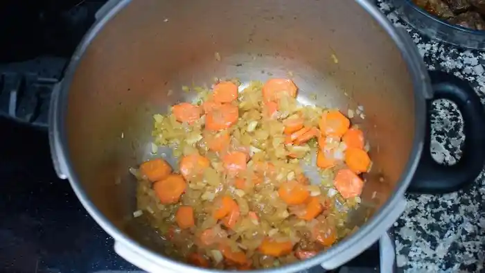 Sofrito de cebolla y zanahoria pochando en la olla del estofado