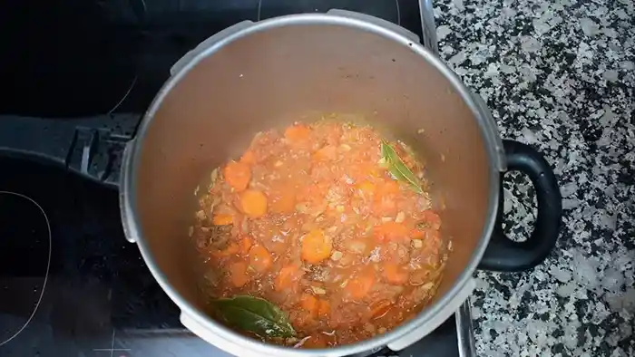 Olla con ternera, zanahoria y salsa de tomate antes de la cocción