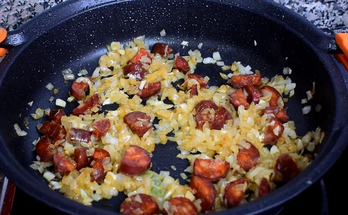 Sofrito de cebolla y chorizo dorándose en cazuela