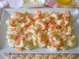Patatas arrieras cocidas con gambas al ajillo y alioli casero servidas en fuente rectangular blanca, con cuencos de alioli y aceite de oliva al fondo