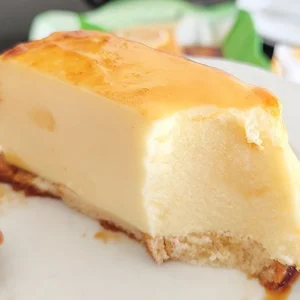 Porción de pastel de limón frío sin horno servida en plato blanco mostrando el corte cremoso, la base dorada y el caramelo que escurre