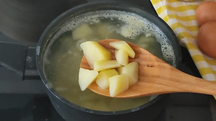 Patatas troceadas cociéndose en agua con sal para ensalada campera de garbanzos