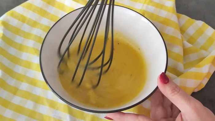 Emulsionando vinagreta de mostaza con varillas para ensalada de garbanzos