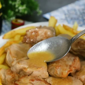 Solomillo al whisky con salsa casera servido sobre patatas fritas.