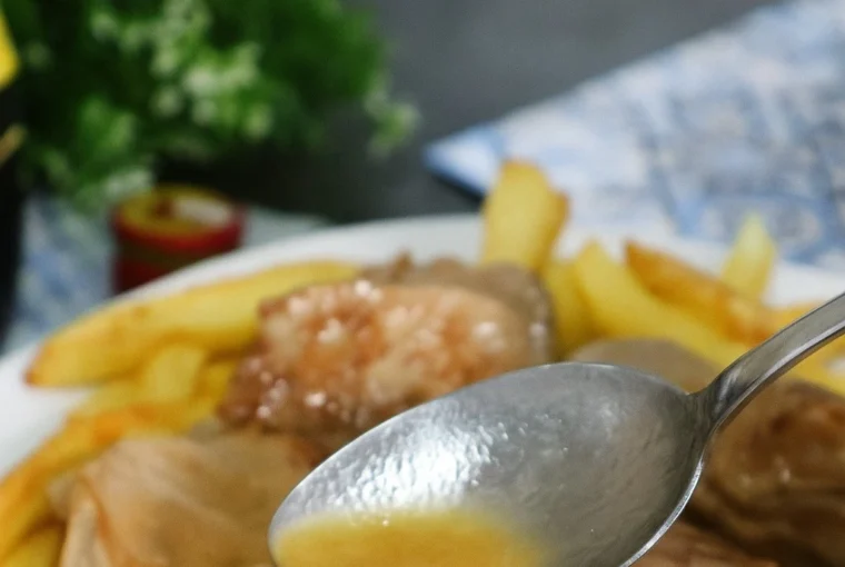 Solomillo al whisky con salsa casera servido sobre patatas fritas.