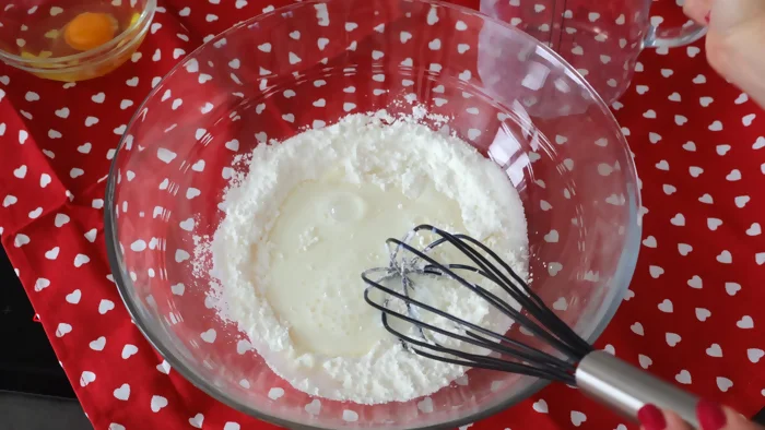 Maizena y azúcar mezclándose con leche fría en un bol para base de crema pastelera