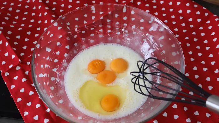 Añadiendo huevo entero y yemas a la mezcla de maizena para crema pastelera casera
