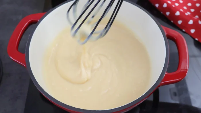 Cocinando crema pastelera a fuego medio mientras espesa, removiendo constantemente con varillas