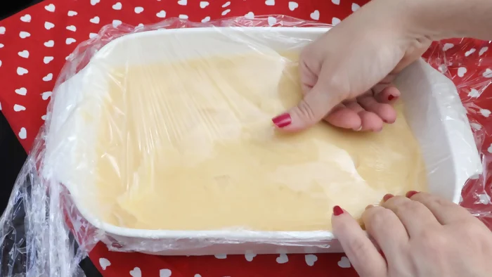 Crema pastelera recién hecha cubierta con film transparente tocando la superficie para evitar costra