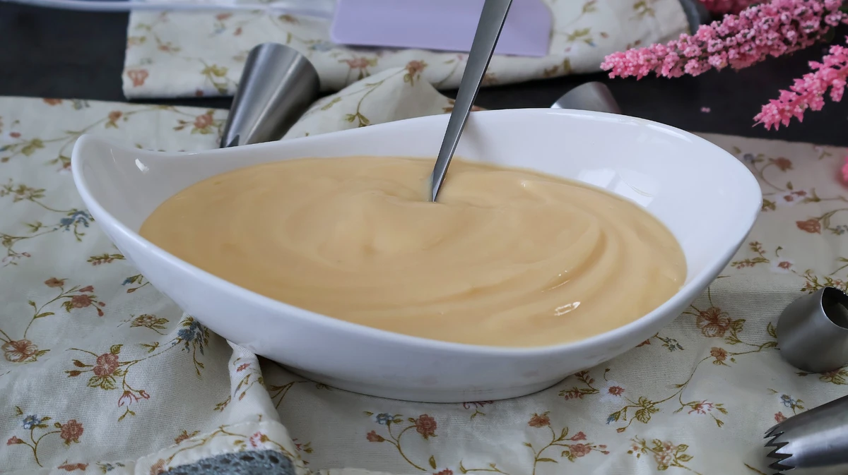 Crema pastelera en cuenco con cucharilla y manga pastelera