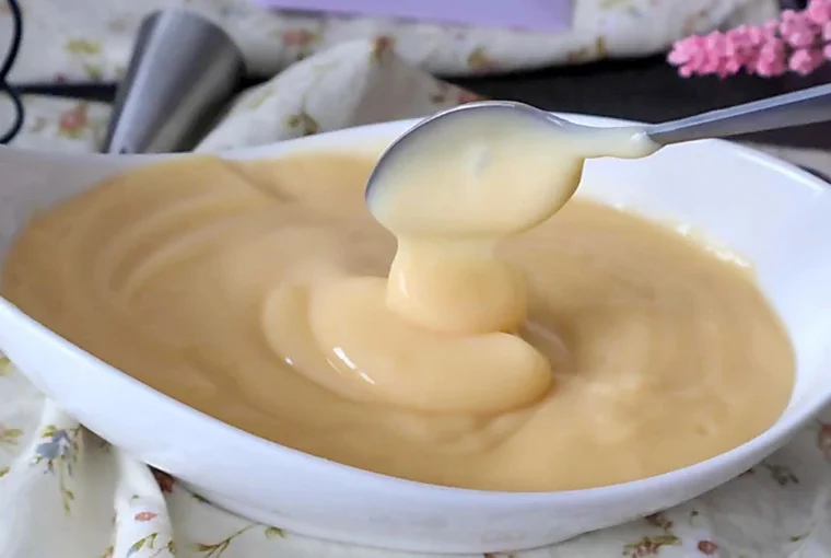 Crema pastelera casera de textura suave y brillante en cuenco blanco