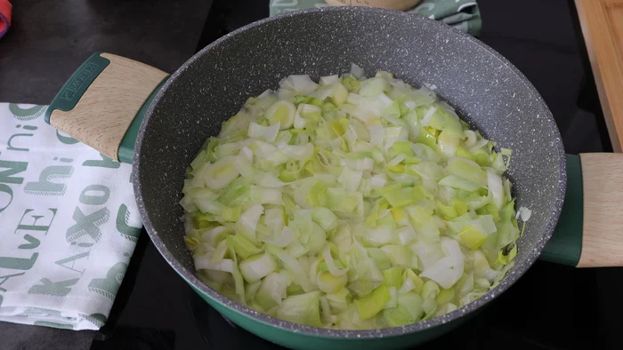 Puerros troceados cocinándose en sartén con aceite y mantequilla