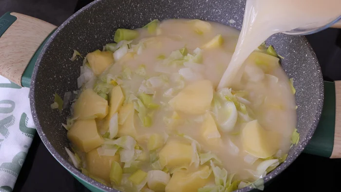 Patatas y puerros cocinándose en caldo vegetal claro