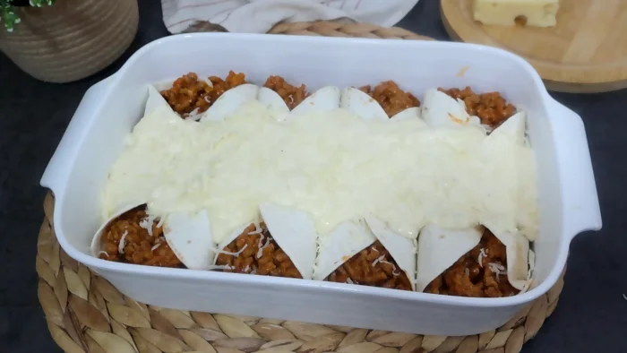 Salsa de queso emmental vertida sobre wraps antes del gratinado