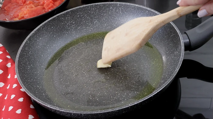 Ajo frotado sobre sartén con aceite.