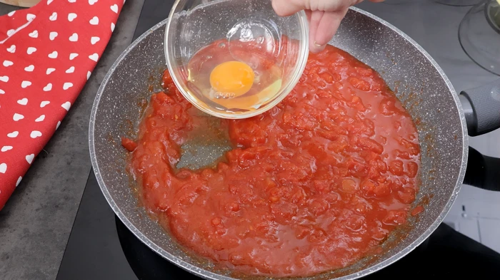 Añadiendo un huevo fresco a la salsa.
