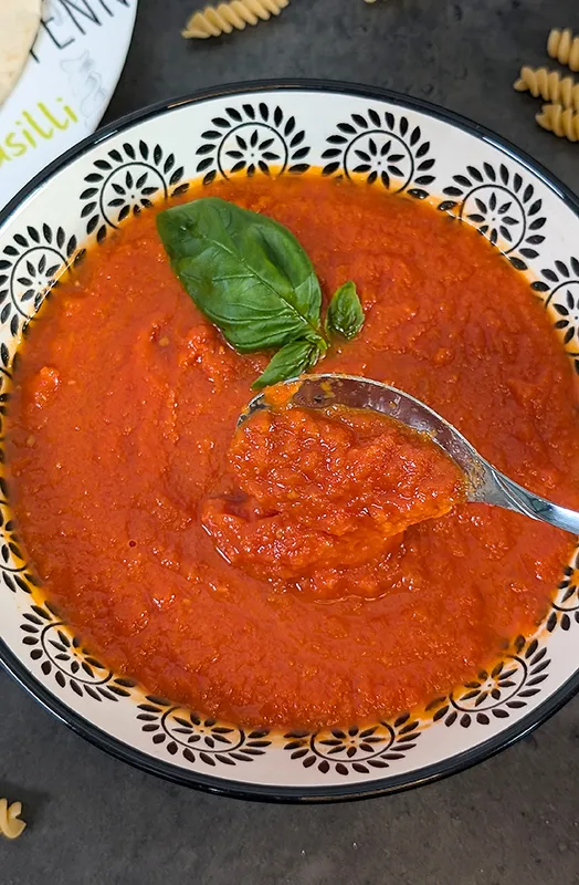 Cucharada de salsa de tomate con albahaca fresca