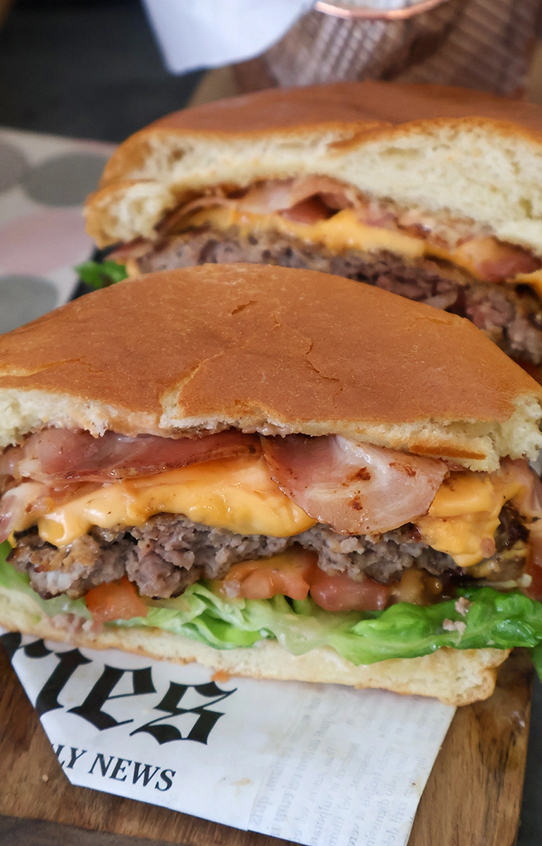 Cheeseburger casera en corte vertical con capas de queso, carne y vegetales