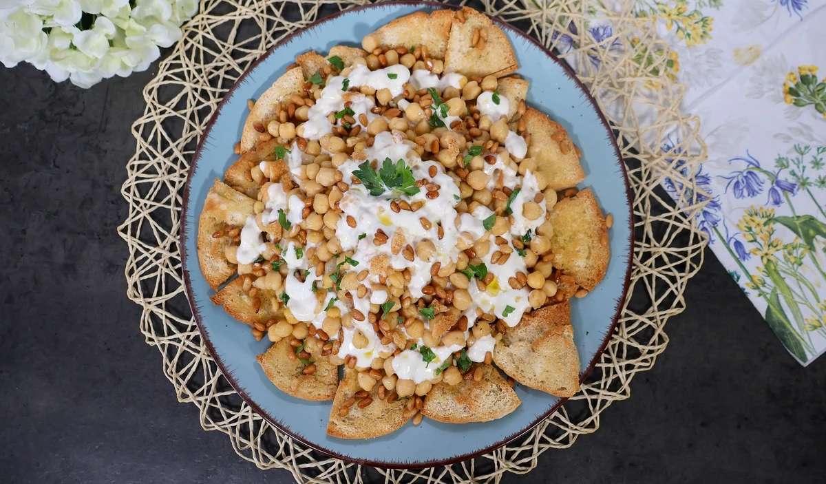 Fatteh servido sobre plato azul, decorado con perejil fresco