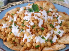 Fatteh de garbanzos con yogur y piñones sobre pan de pita crujiente
