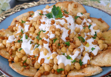 Fatteh de garbanzos con yogur y piñones sobre pan de pita crujiente
