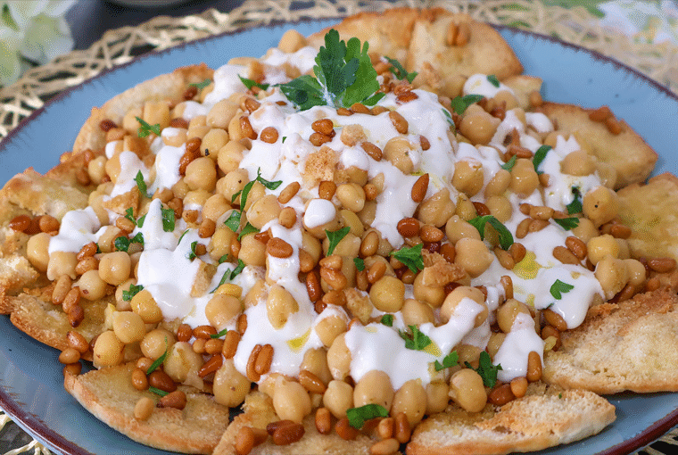 Fatteh de garbanzos con yogur y piñones sobre pan de pita crujiente
