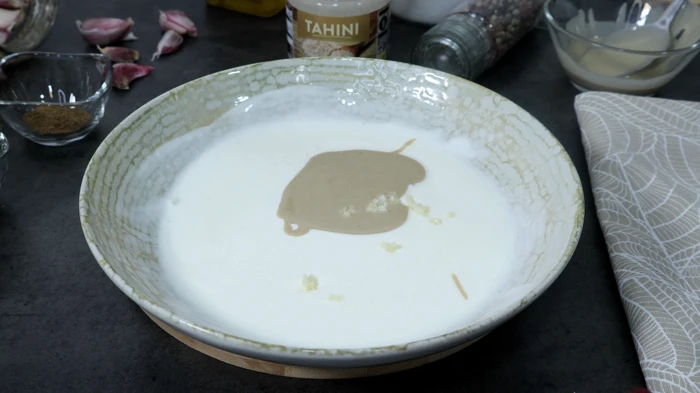 Yogur con tahini y ajo en bol