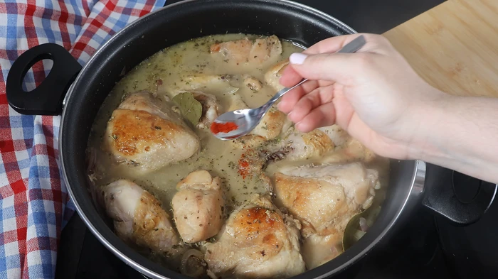 Cucharada de azafrán y hierbas aromáticas sobre el pollo con caldo.  